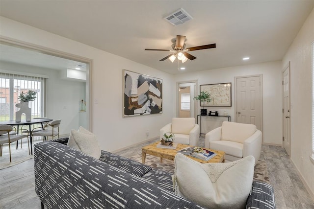 living room with a ceiling fan, recessed lighting, visible vents, and light wood finished floors