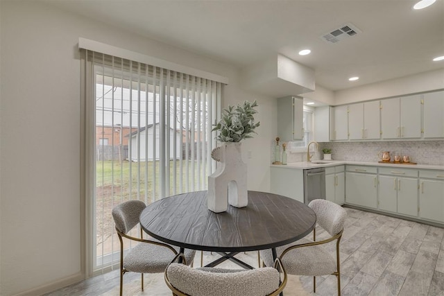 dining room with light wood-style flooring, plenty of natural light, visible vents, and recessed lighting