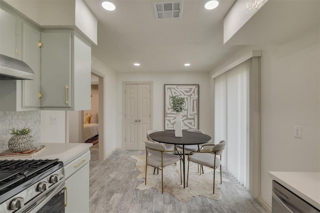 kitchen with dishwasher, light countertops, visible vents, and decorative backsplash