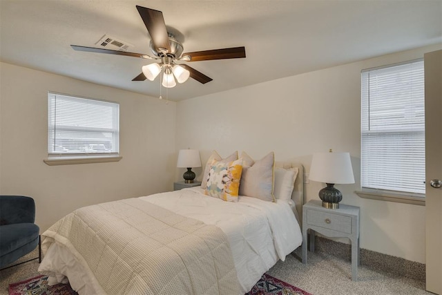 bedroom with carpet, visible vents, and ceiling fan