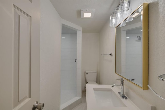 full bath with tiled shower, vanity, and toilet