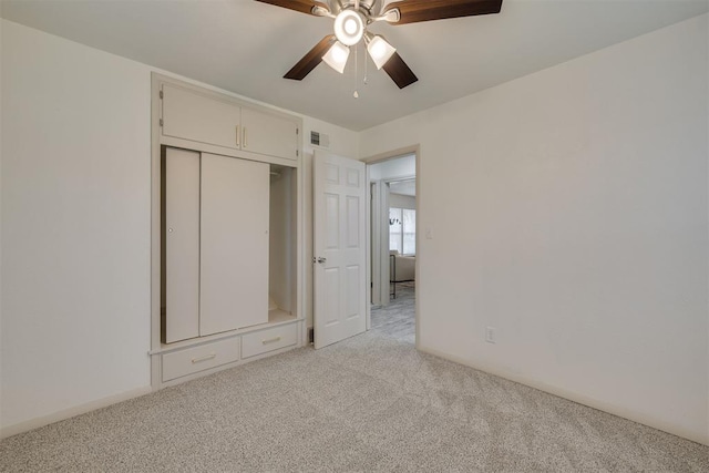 unfurnished bedroom featuring a closet, light carpet, ceiling fan, and visible vents