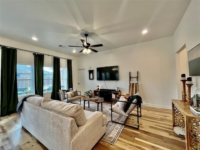 living room with light wood-type flooring, ceiling fan, visible vents, and recessed lighting