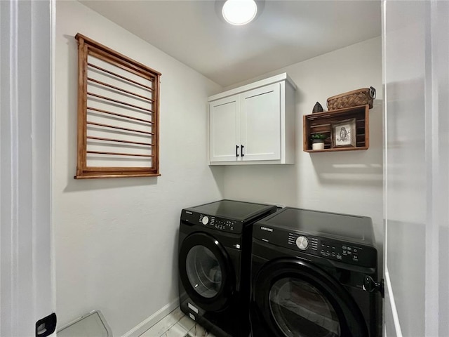 clothes washing area featuring cabinet space, baseboards, and separate washer and dryer