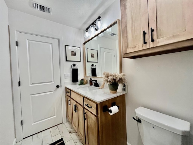 half bath featuring toilet, marble finish floor, visible vents, and vanity