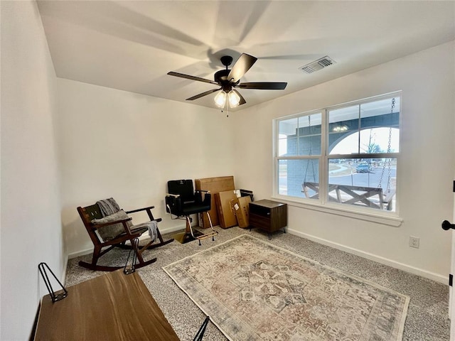 carpeted office space featuring ceiling fan, visible vents, and baseboards