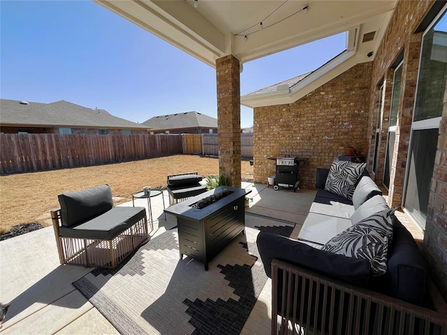 view of patio / terrace with fence and an outdoor living space with a fire pit