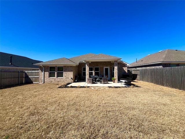 back of property featuring a fenced backyard, a patio, and a lawn