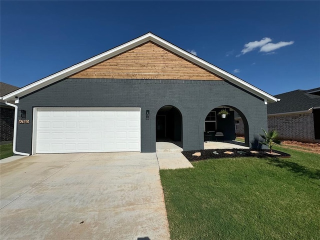 view of front of home with concrete driveway, brick siding, an attached garage, and a front yard