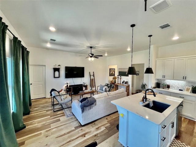 16340 Cold Fire Rd, Oklahoma City, OK 73170 - kitchen with a sink, a ceiling fan, light wood-style floors, tasteful backsplash, and white cabinets