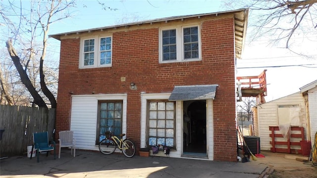 back of property with brick siding and fence