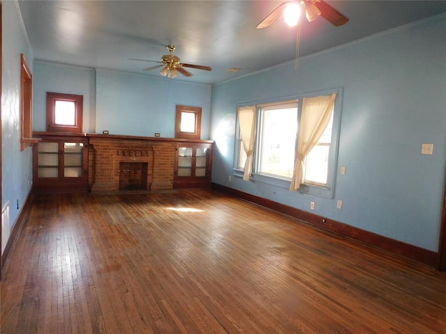 unfurnished living room featuring baseboards, a healthy amount of sunlight, a fireplace, and hardwood / wood-style floors