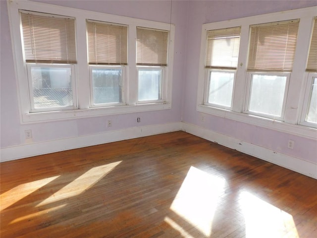 spare room featuring baseboards and wood finished floors