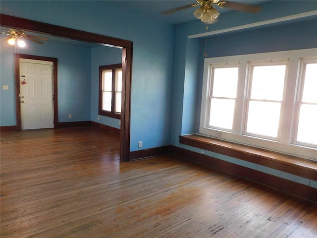 spare room with a ceiling fan, baseboards, and wood finished floors