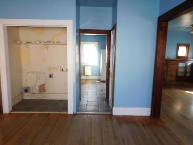 hallway featuring baseboards and wood finished floors