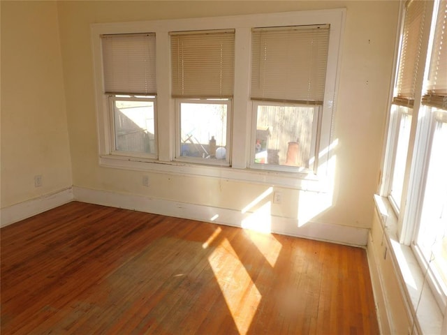 empty room with baseboards and hardwood / wood-style floors