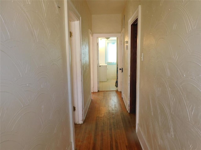 hallway with dark wood-style floors and baseboards