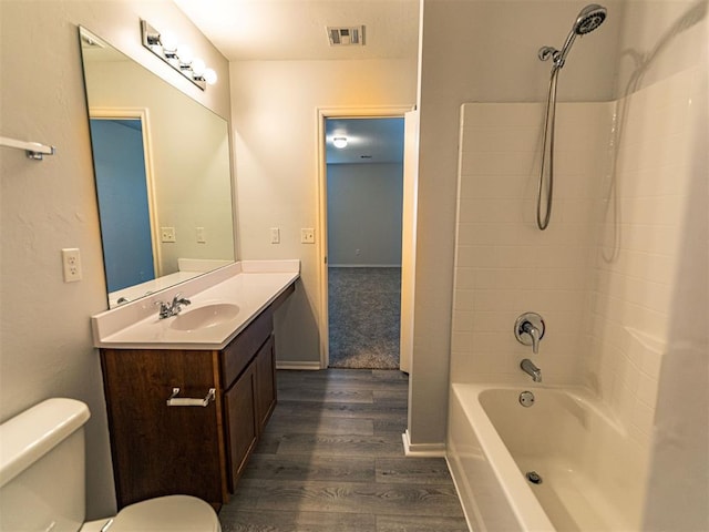 bathroom with shower / bathtub combination, visible vents, toilet, vanity, and wood finished floors