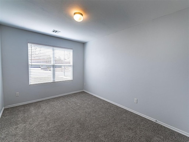 carpeted spare room with visible vents and baseboards