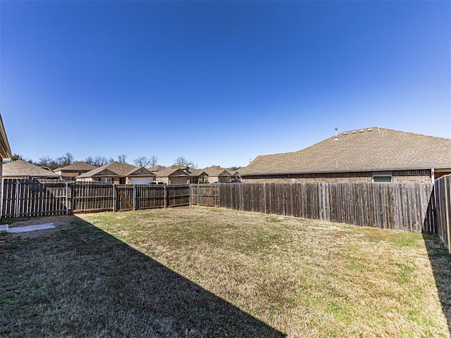 view of yard with a fenced backyard and a residential view