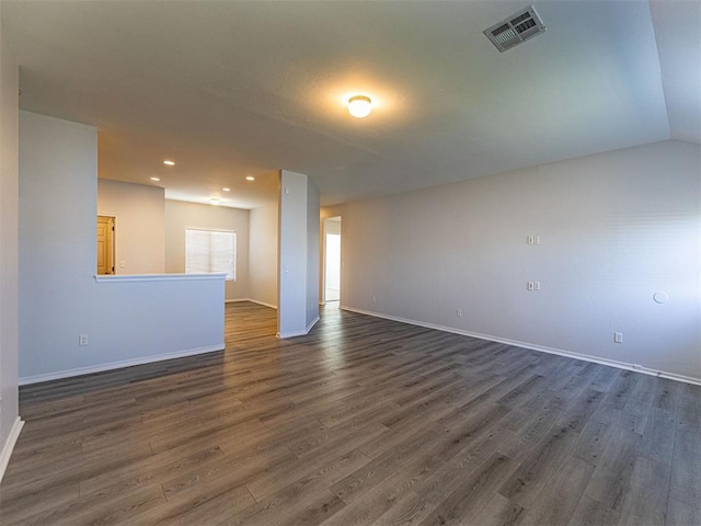 spare room with dark wood finished floors, recessed lighting, visible vents, vaulted ceiling, and baseboards