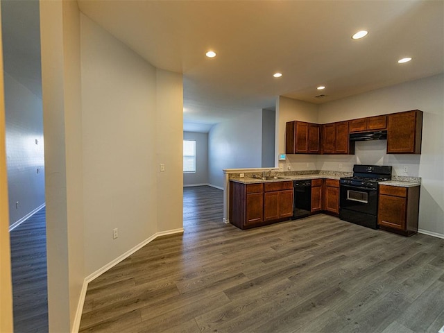 kitchen featuring dark wood-type flooring, range hood, light countertops, and black appliances