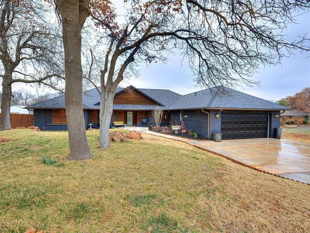 view of front of property featuring brick siding, concrete driveway, a front yard, fence, and a garage