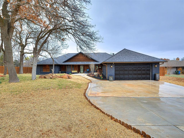 view of front of house featuring a garage, brick siding, fence, concrete driveway, and a front lawn