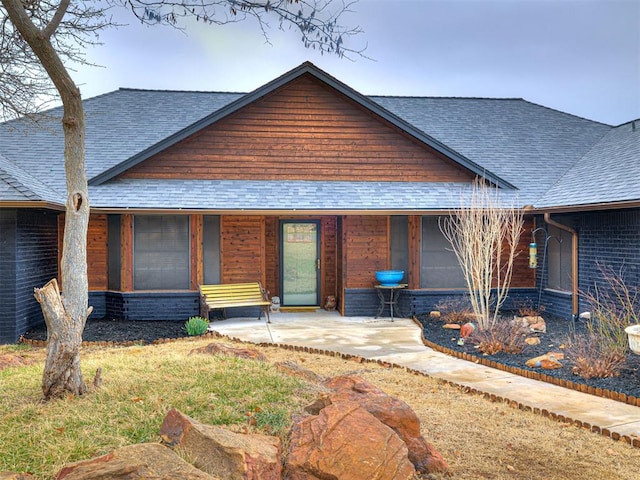 view of front of property featuring covered porch and roof with shingles