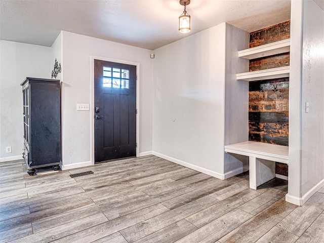 entryway featuring baseboards and wood finished floors