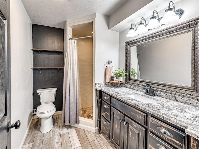 full bath with a textured ceiling, toilet, wood finished floors, vanity, and a shower stall