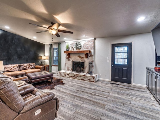 living area with a textured ceiling, a fireplace, and wood finished floors