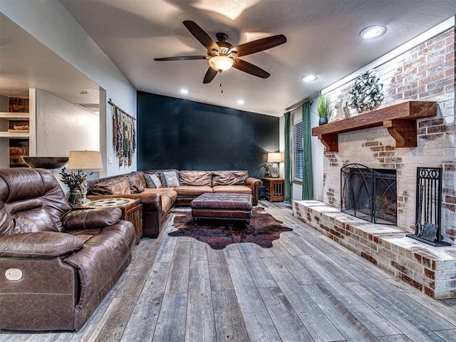 living room featuring a fireplace, recessed lighting, a ceiling fan, a textured ceiling, and hardwood / wood-style floors