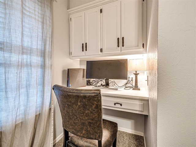 office area featuring a textured wall and built in desk