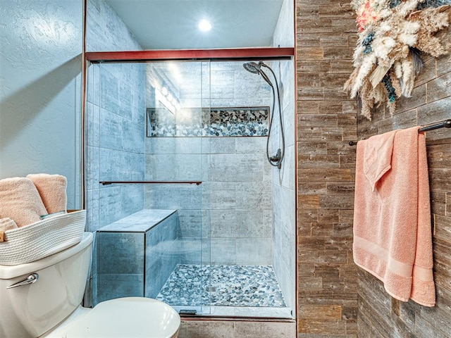 bathroom featuring a stall shower and toilet