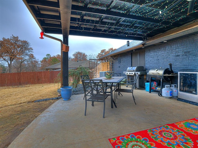 view of patio / terrace featuring outdoor dining area, a grill, and fence