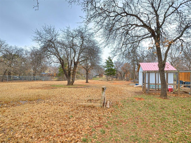 view of yard featuring an outbuilding, fence, and exterior structure