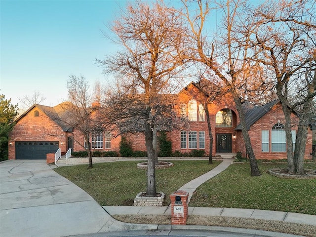 traditional home with a front yard, brick siding, driveway, and an attached garage