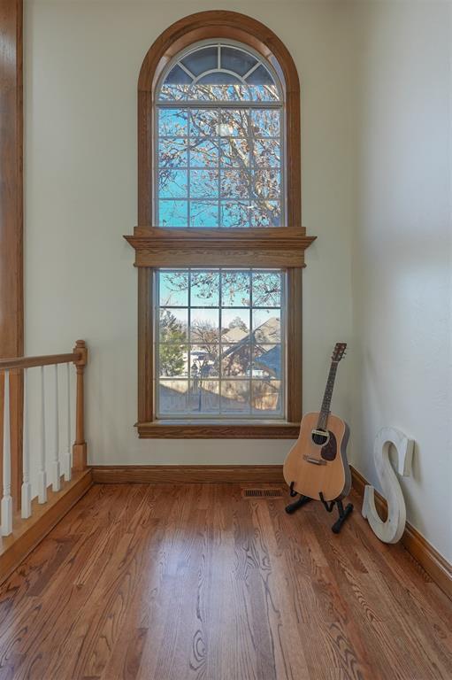 interior details featuring wood finished floors, visible vents, and baseboards