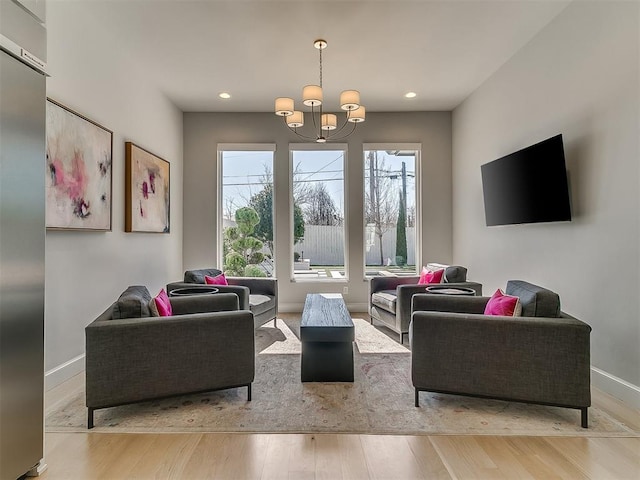 living room featuring recessed lighting, wood finished floors, baseboards, and a chandelier