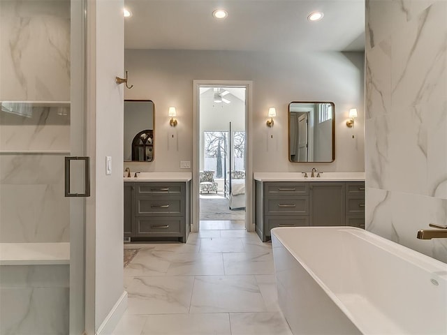 bathroom featuring two vanities, recessed lighting, marble finish floor, and a sink