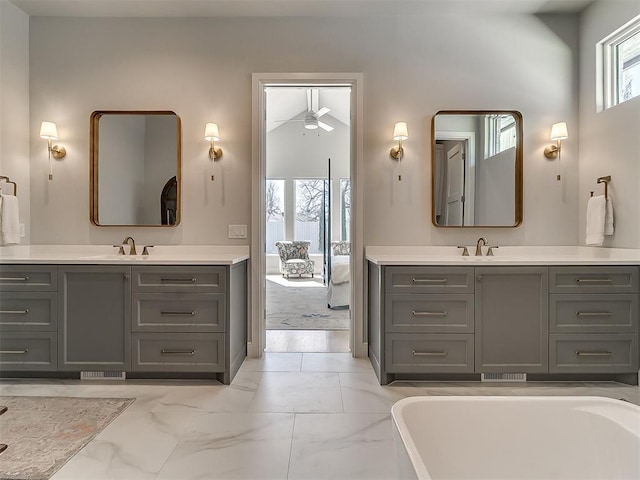 bathroom featuring marble finish floor, two vanities, and a sink