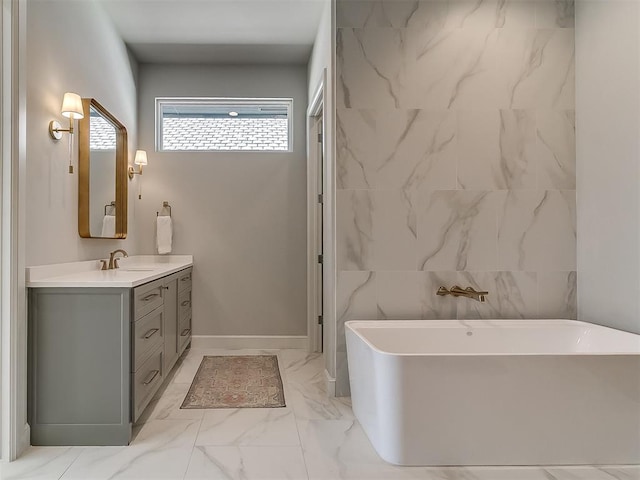 bathroom featuring a freestanding tub, marble finish floor, and vanity