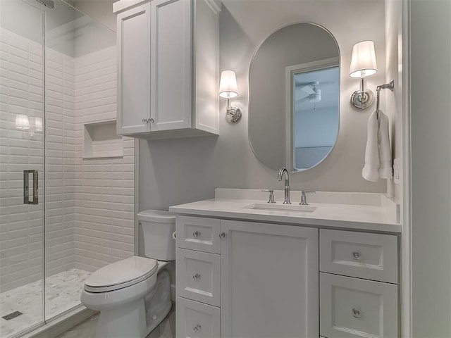 full bathroom featuring a stall shower, toilet, and vanity