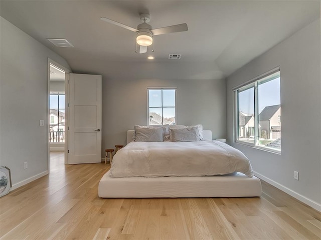 bedroom with light wood finished floors, visible vents, a ceiling fan, and baseboards