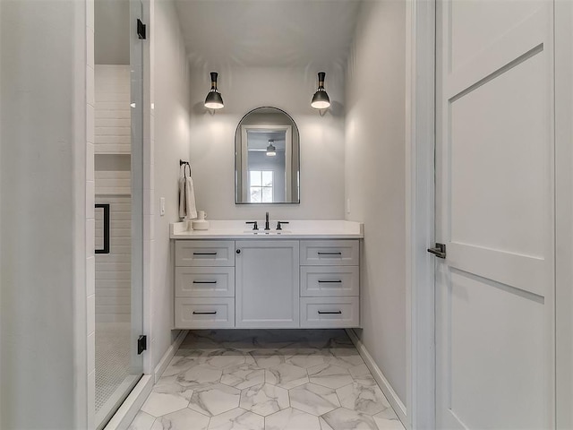 bathroom featuring baseboards, marble finish floor, a stall shower, and vanity