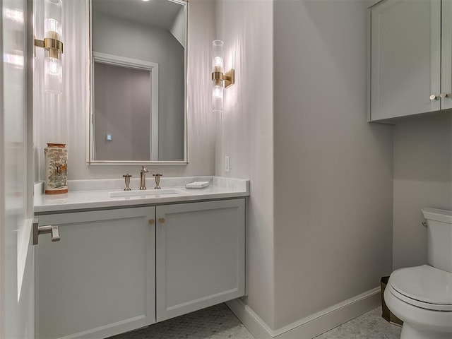 bathroom featuring baseboards, toilet, and vanity