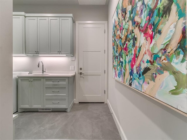 bar with a sink, visible vents, and baseboards