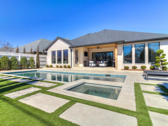 back of property featuring ceiling fan, fence, roof with shingles, a patio area, and an in ground hot tub