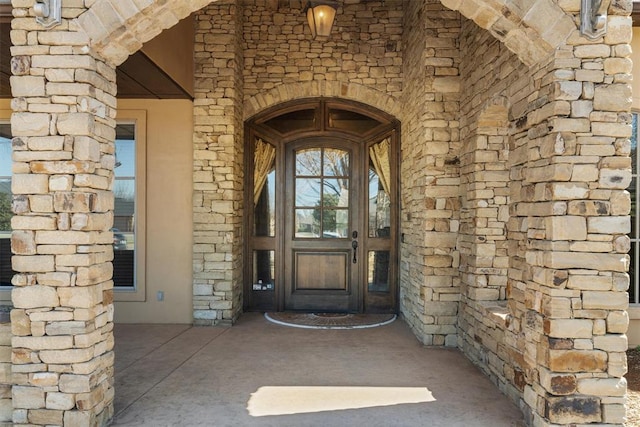 property entrance featuring stone siding